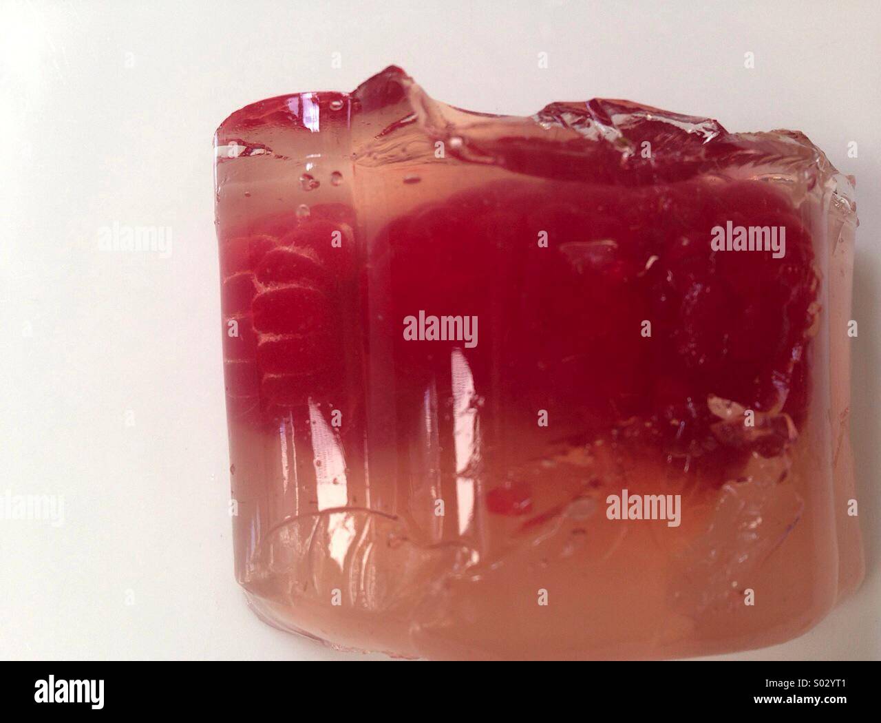 Raspberries in clear Vodka desert jelly on a white background Stock ...