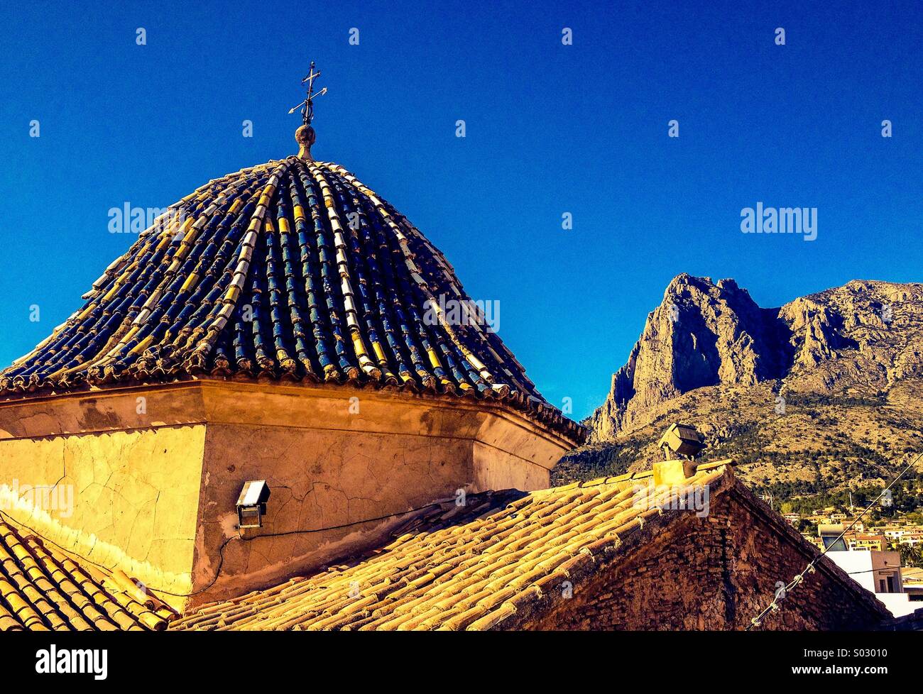 Rooftop view of Spanish church dome with mountain in background Stock