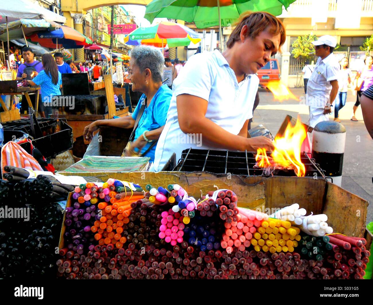 Asian street vendor selling colored candles outside of quiapo churh in