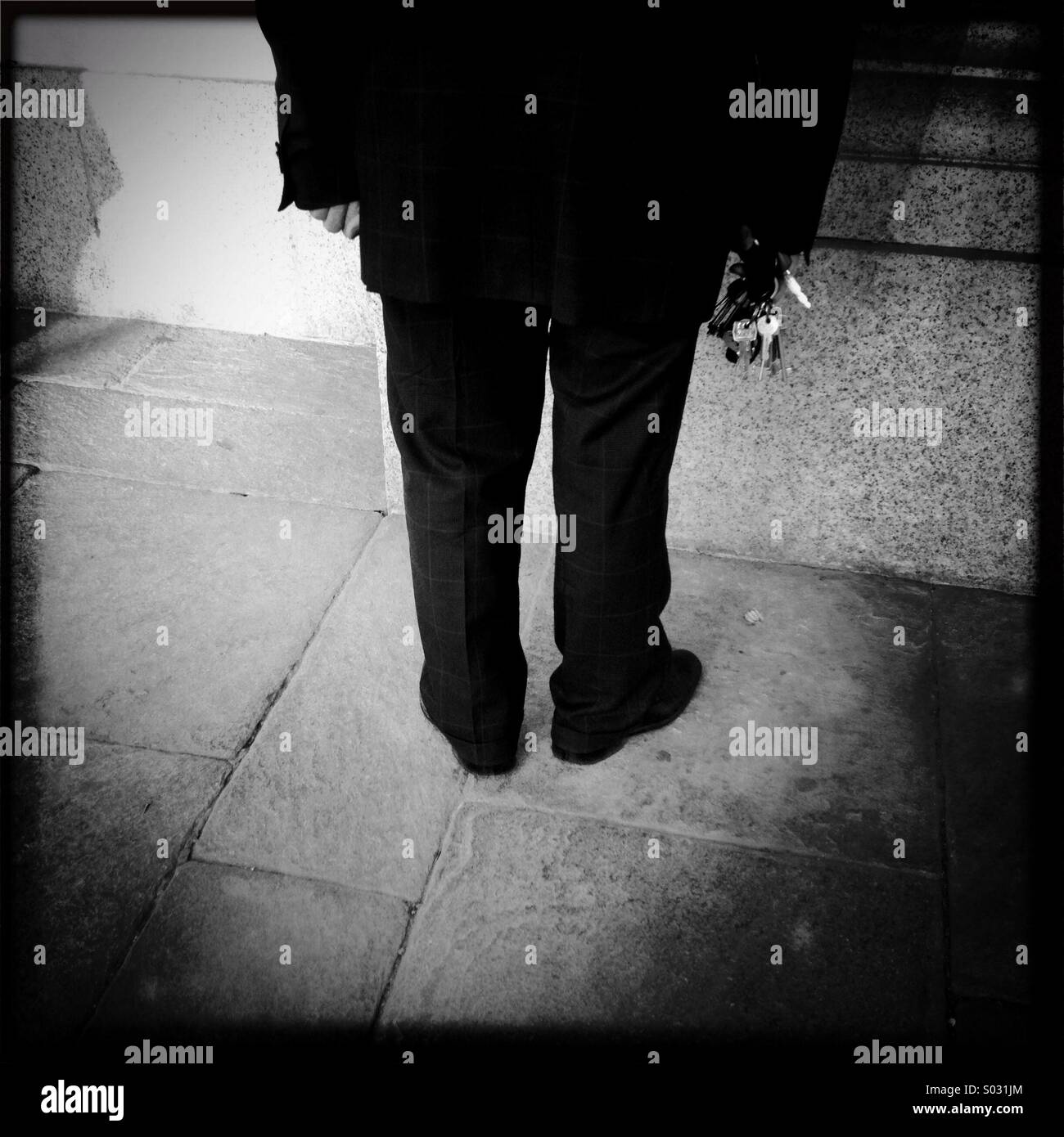 Man with keys mysterious shoulders mistery black dark situation back view prisoner Stock Photo