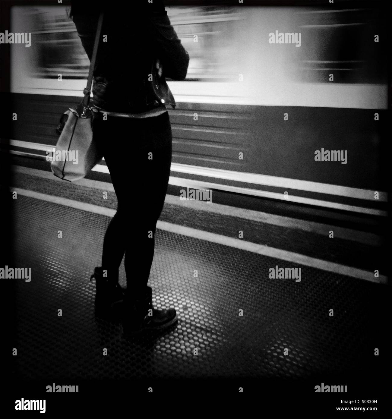 Underground station standing girl woman waiting train stops urban life loneliness dark mood style platform Stock Photo