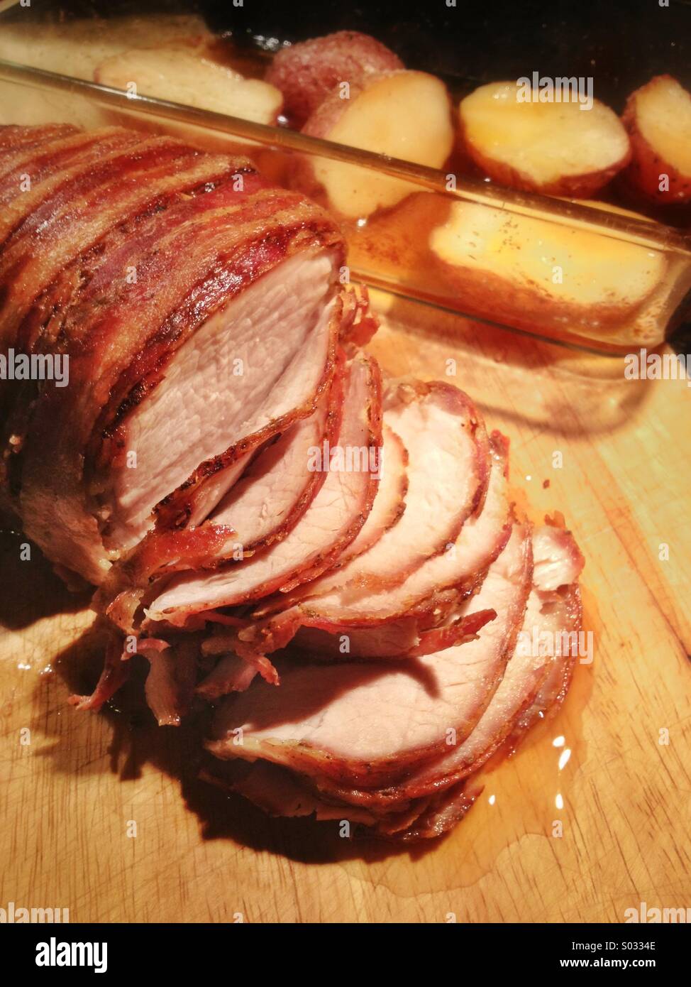 Sliced pork roast with potatoes on cutting board - Smartphone Captured Stock Image