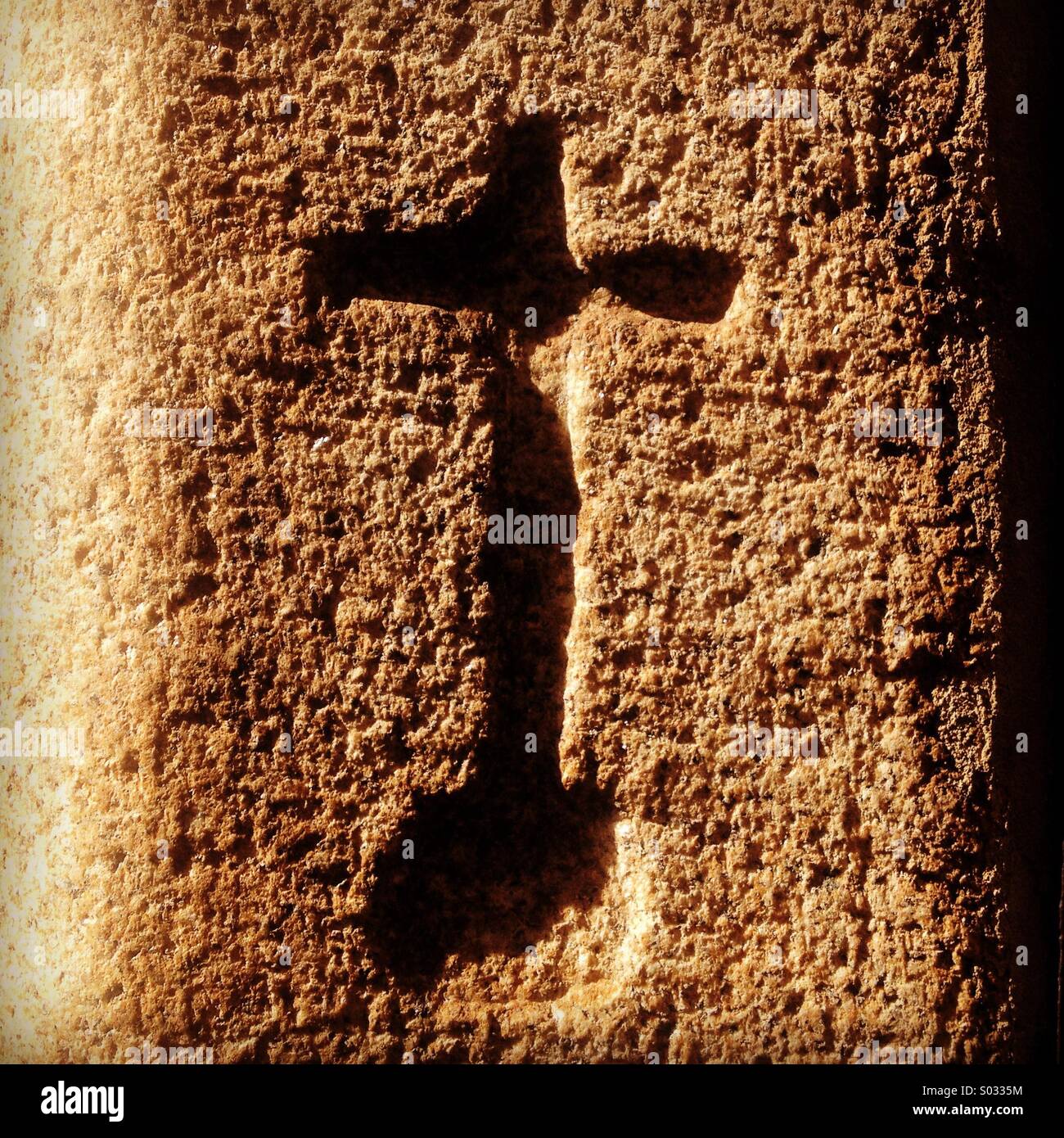 A cross carved in stone decorates a medieval house in Caceres, Extremadura, Spain - Smartphone Captured Stock Image