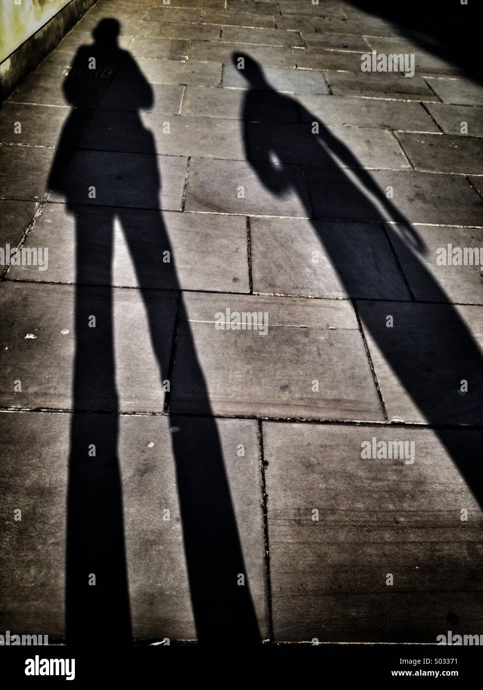 Long shadows of two women on a pavement Stock Photo - Alamy
