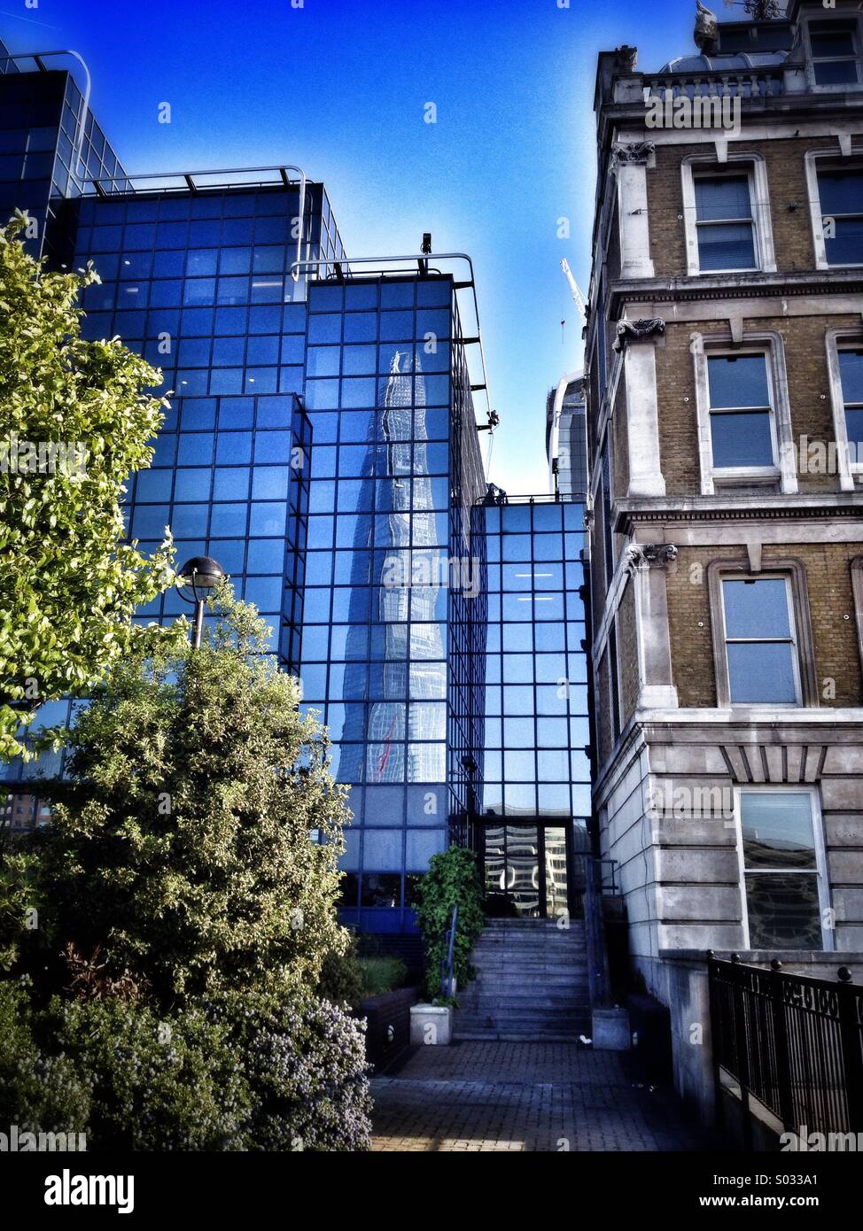 Office buildings on the north bank of the Thames reflect the Shard skyscraper in their windows - Smartphone Captured Stock Image