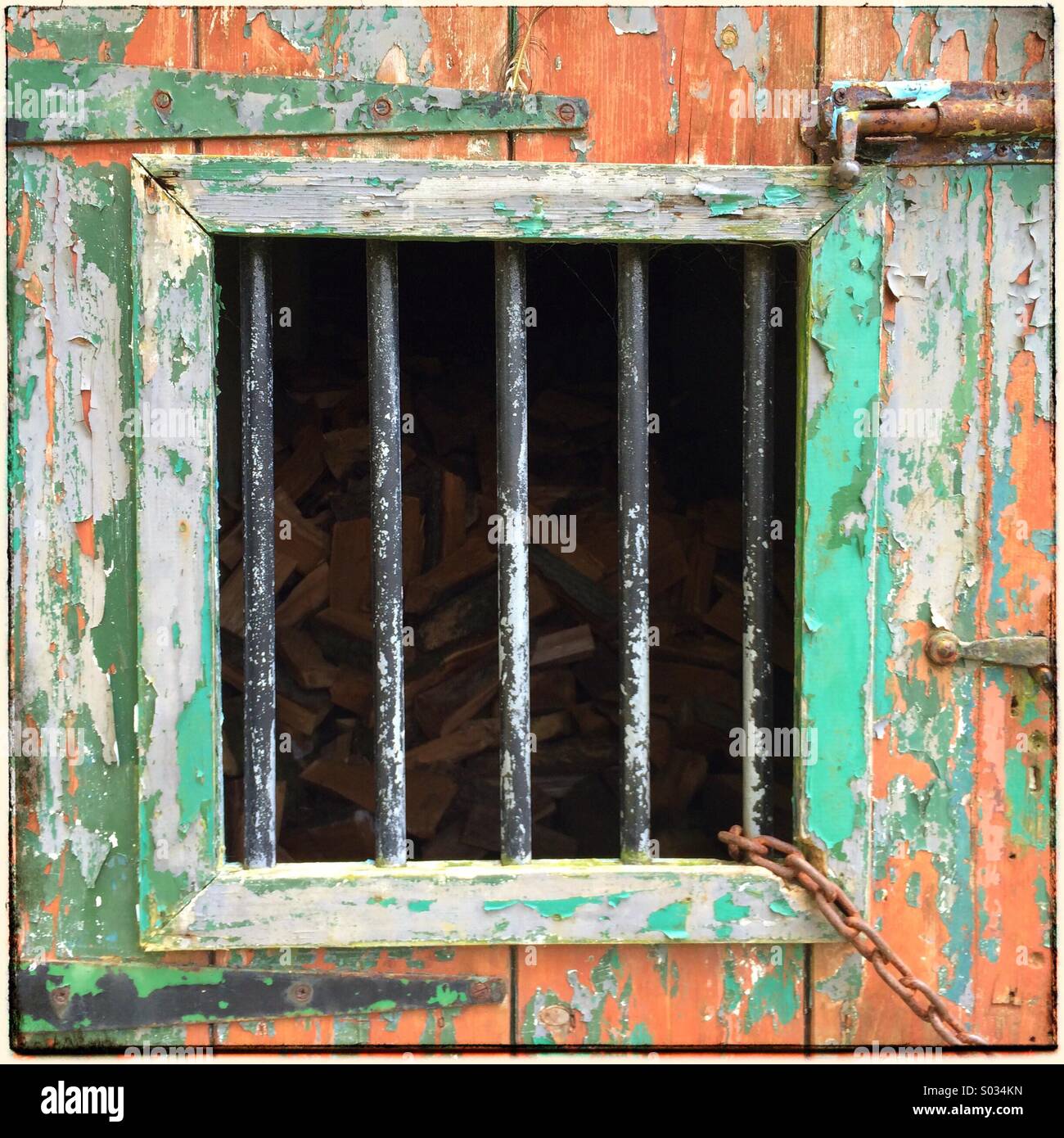 Old and distressed wooden door with steel bars on window to add to