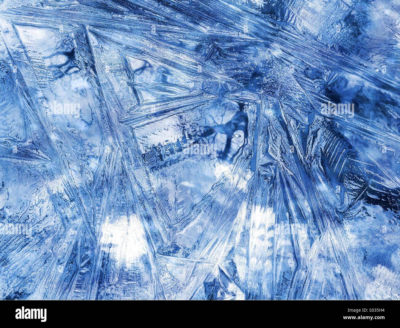 Ice crystal pattern on a freezing pond with blue effect Stock Photo