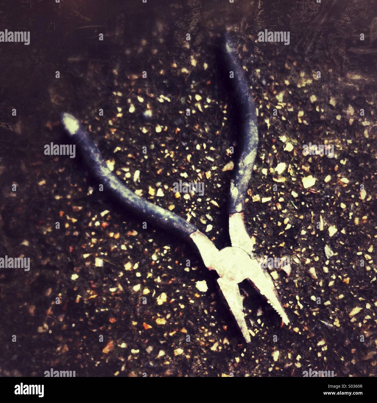 Pliers resting on a textured surface reflecting natural light at a construction site in the afternoon - Smartphone Captured Stock Image