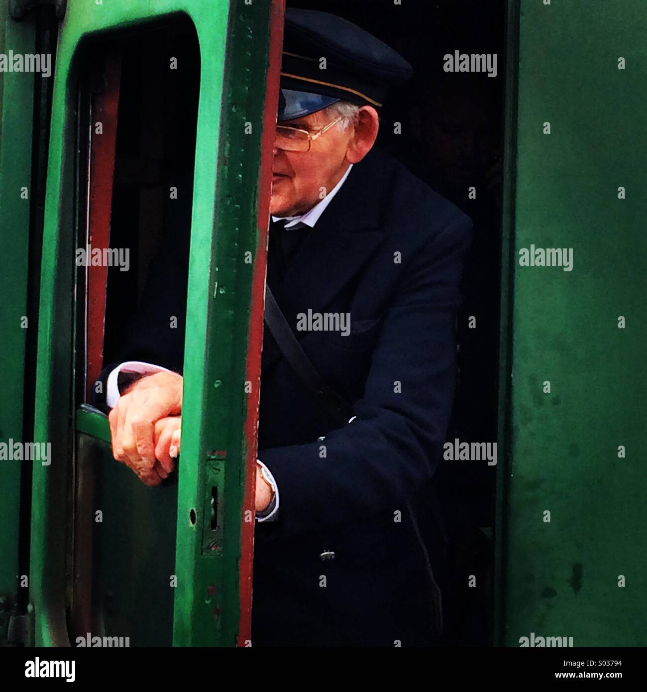 Great Central Railway Guard alighting from a train carriage. Stock Photo