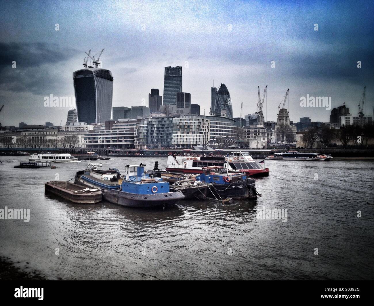River Thames in London, barges and boats with landmark skyscrapers like the 'Walkie Talkie', the 'Cheesegrater' and the 'Gherkin' in the background. - Smartphone Captured Stock Image