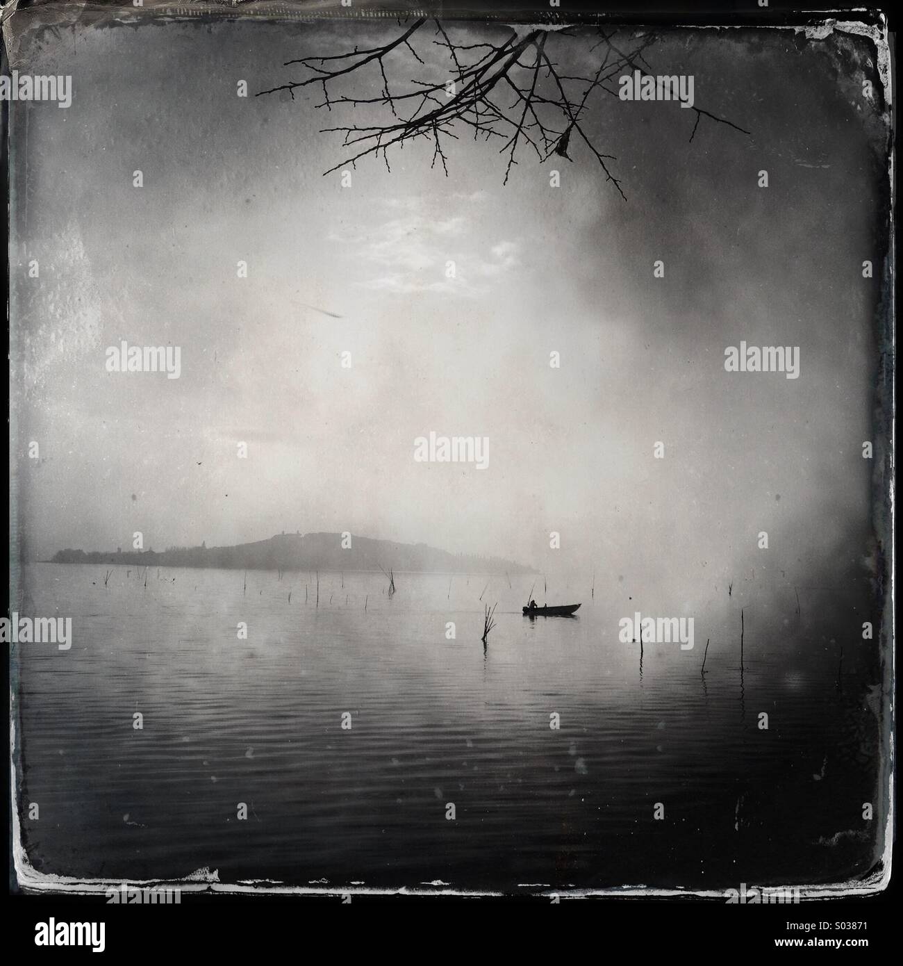 A lonely ship at the lake Trasimeno in the mist in winter - Smartphone Captured Stock Image