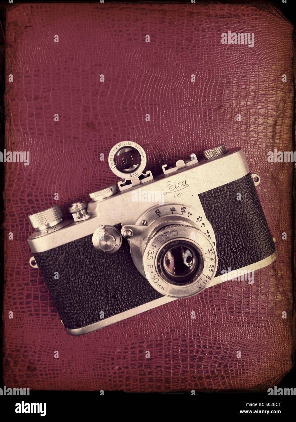 Old analogue camera Leica resting over ref leather - Smartphone Captured Stock Image