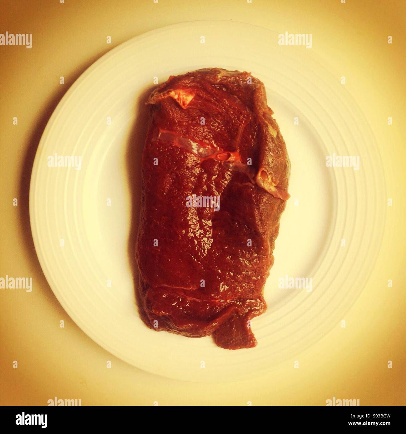 Raw horse meat steak on a white plate - Smartphone Captured Stock Image