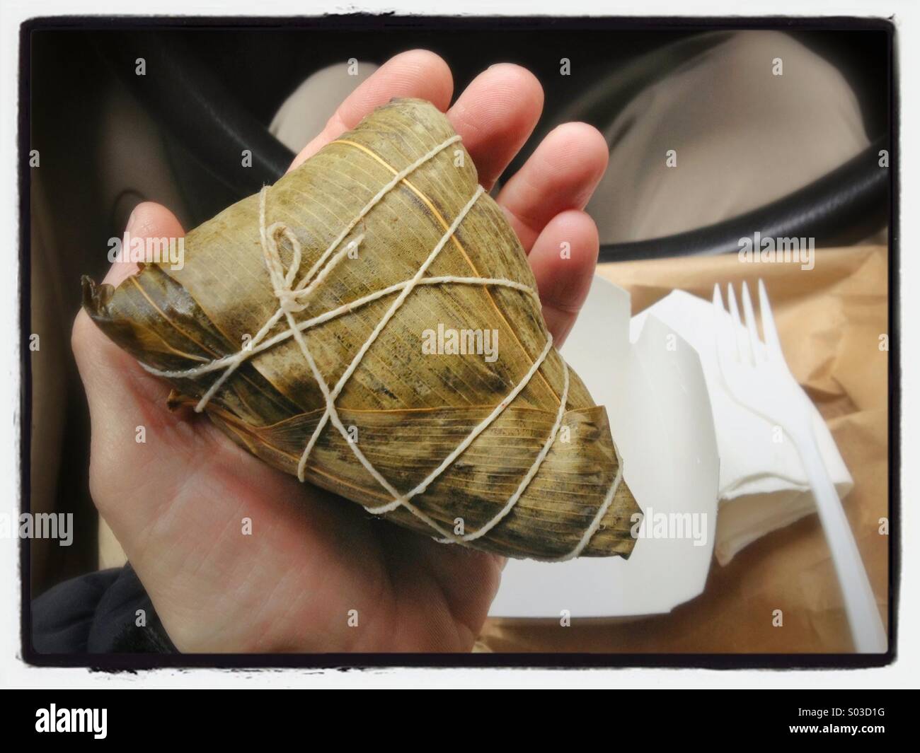 Chinese tamale (Zong-Zi) in mans hand Stock Photo