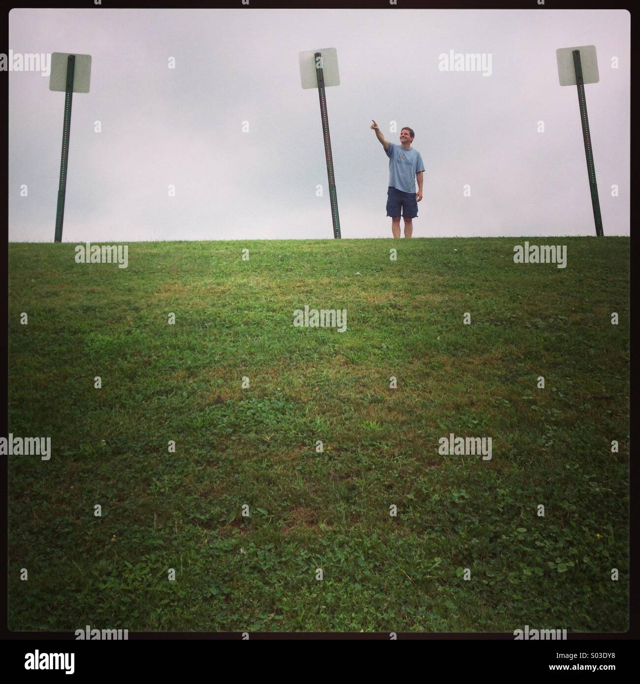 Man standing in field next to three blank signs - Smartphone Captured Stock Image