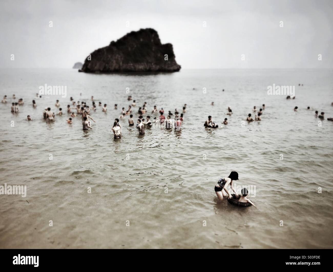 Groups of swimmers in one of the beaches on the island of Cat Ba in Ha Long Bay. - Smartphone Captured Stock Image