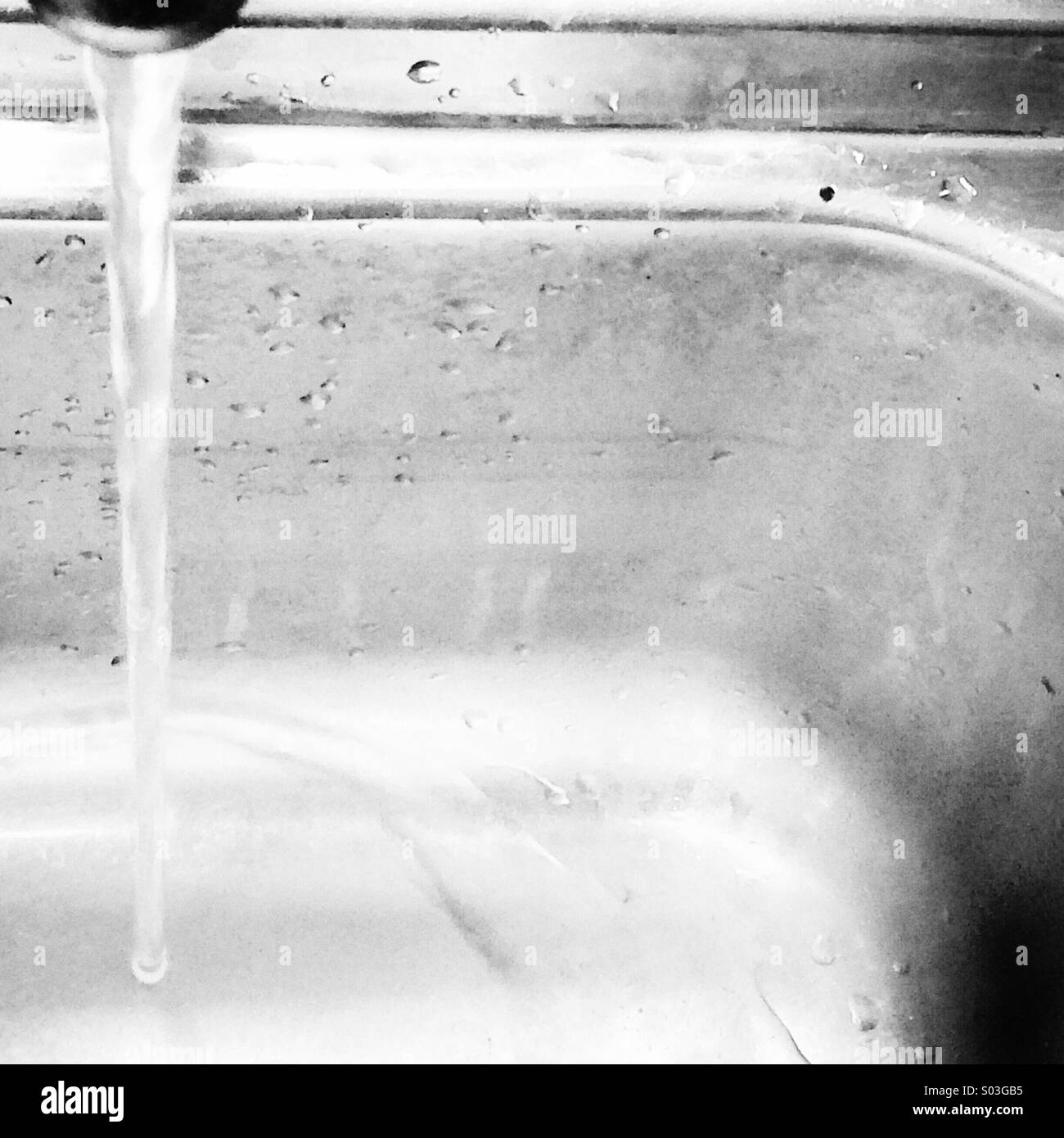Tap running into 1970's stainless steel sink - Smartphone Captured Stock Image