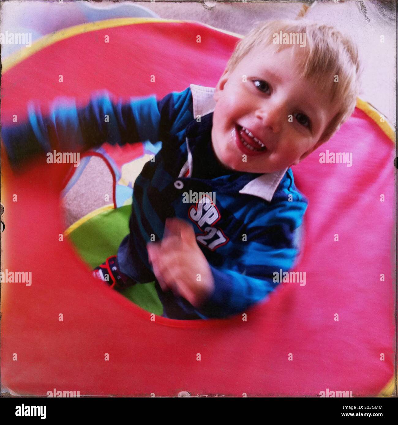 Young boy playing indoors in a small tent. Boy is about two years old. Stock Photo