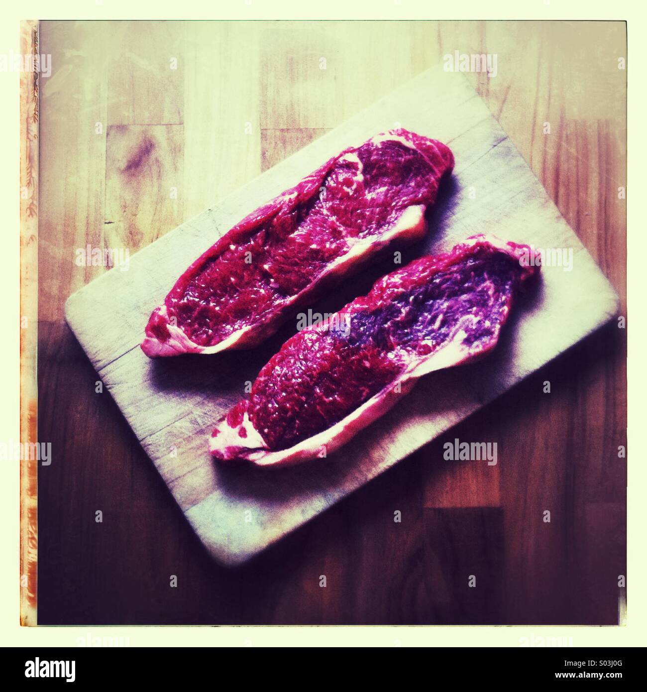 Sirloin steaks on a wooden board - Smartphone Captured Stock Image