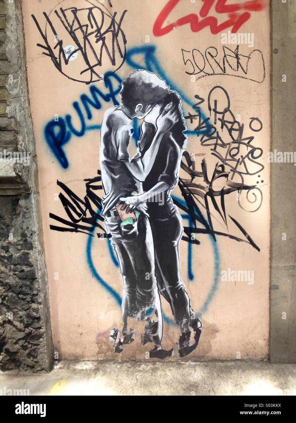 A sticker of a young couple kissing decorates a wall painted with graffiti in Colonia Roma, Mexico City, Mexico - Smartphone Captured Stock Image