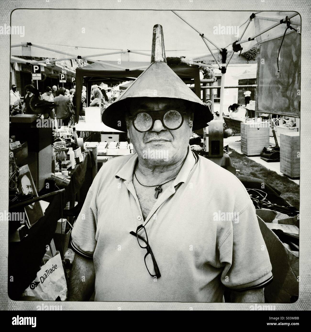 Seller of antique flea market with funnel on his head - Smartphone Captured Stock Image