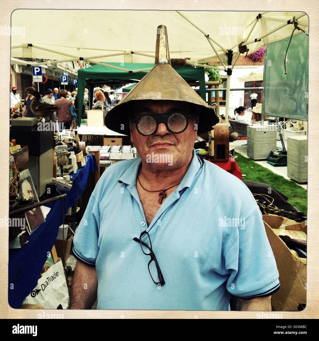 Seller of antique flea market with funnel on his head - Smartphone Captured Stock Image