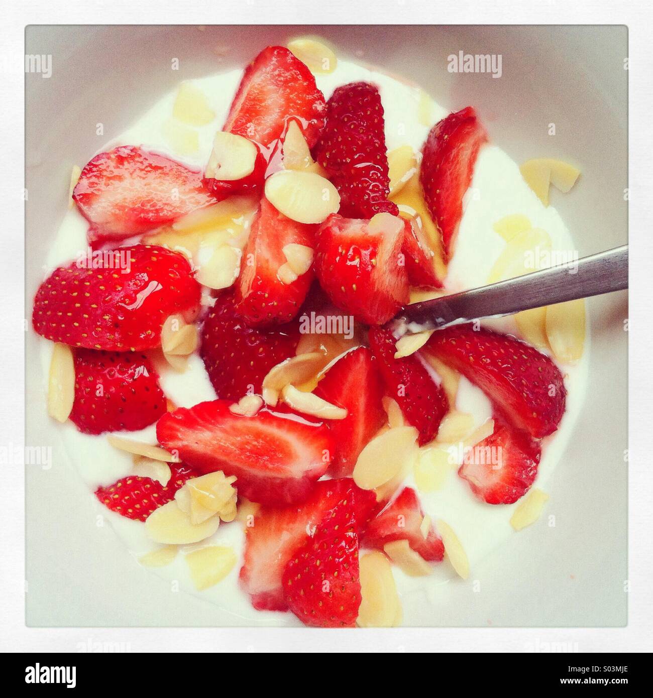 Healthy breakfast of natural yogurt, strawberries, flaked almonds and