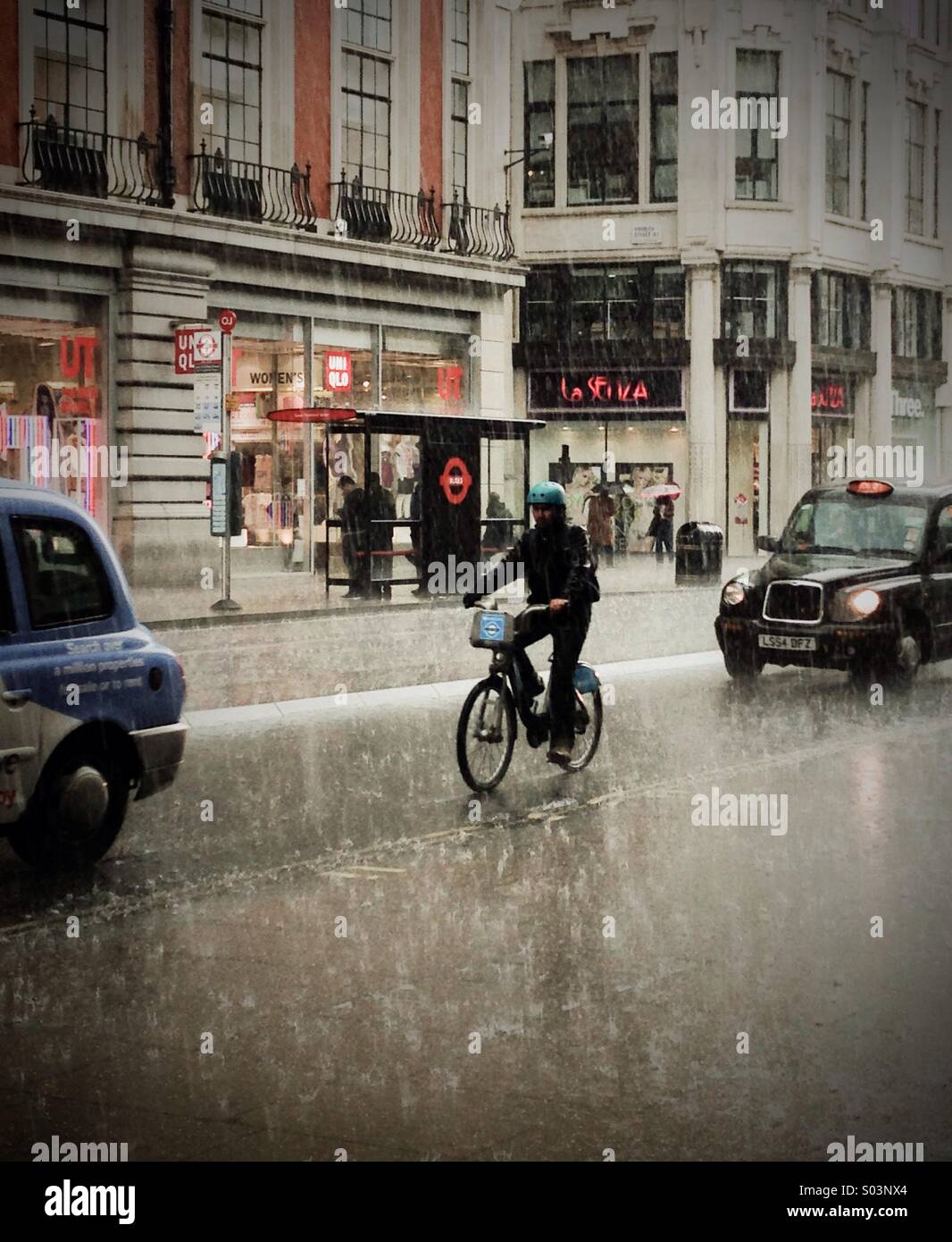Boris Bike cyclist Riding In The Rain - Smartphone Captured Stock Image