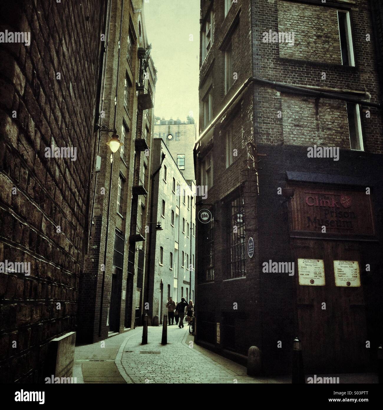 People walk down Clink street in London, site of the notorious prison of the same name - Smartphone Captured Stock Image