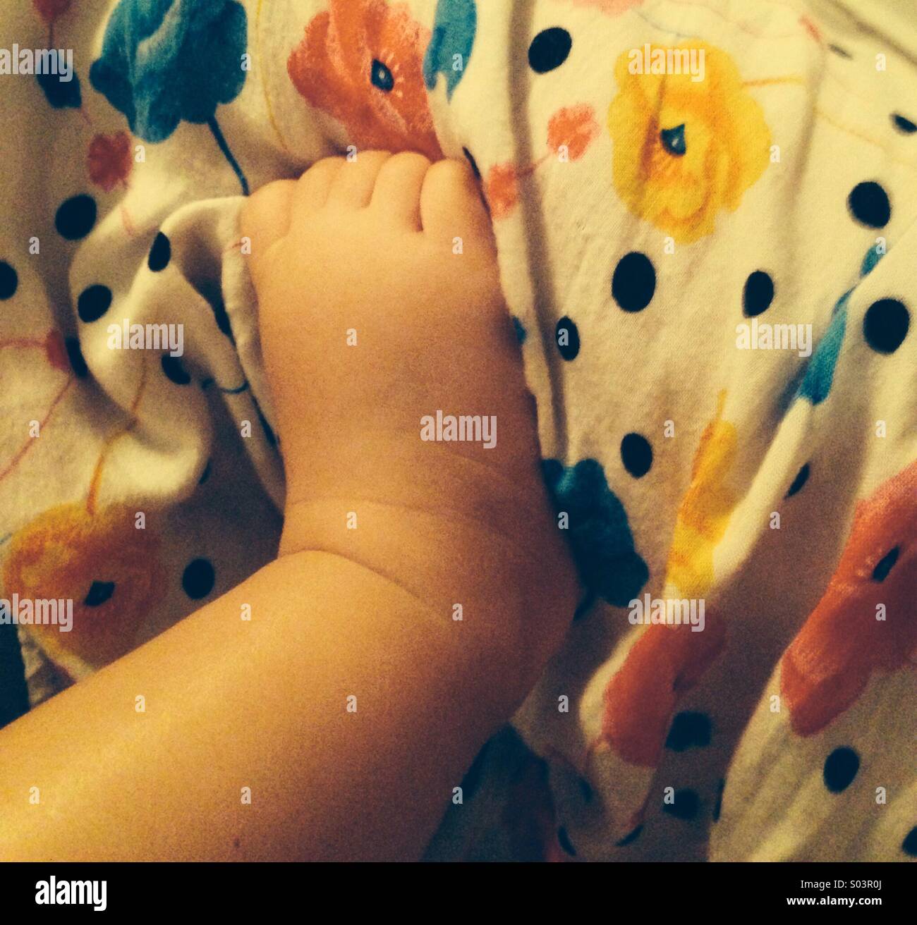 Baby's foot gripping mum Stock Photo