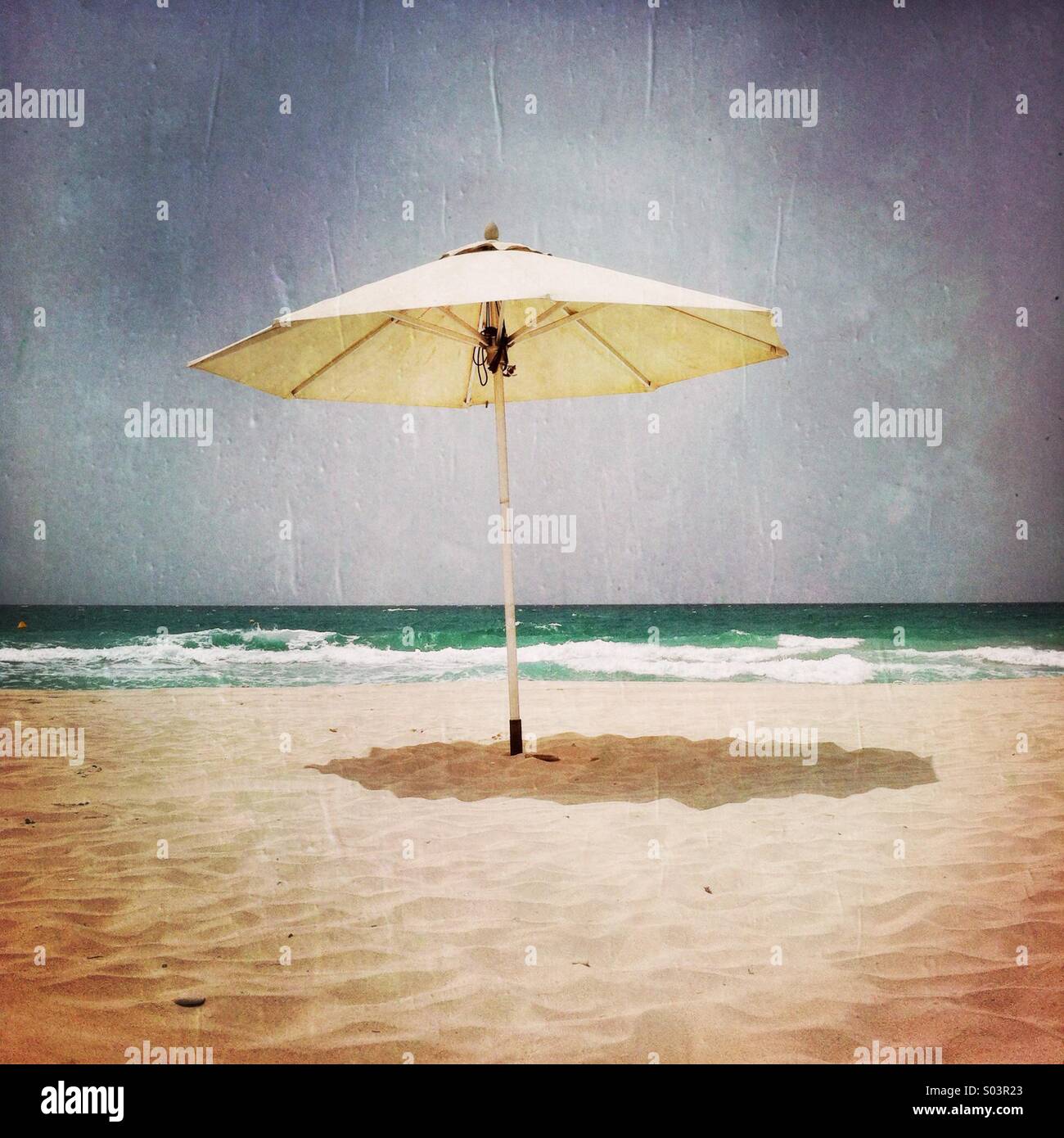 A single umbrella on the beach. Abu Dhabi, U.A.E. - Smartphone Captured Stock Image
