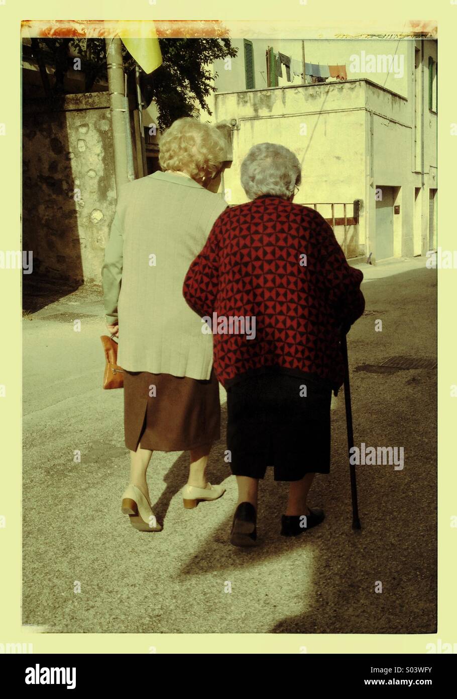 Two elderly women walking on the street seen from back - Smartphone Captured Stock Image