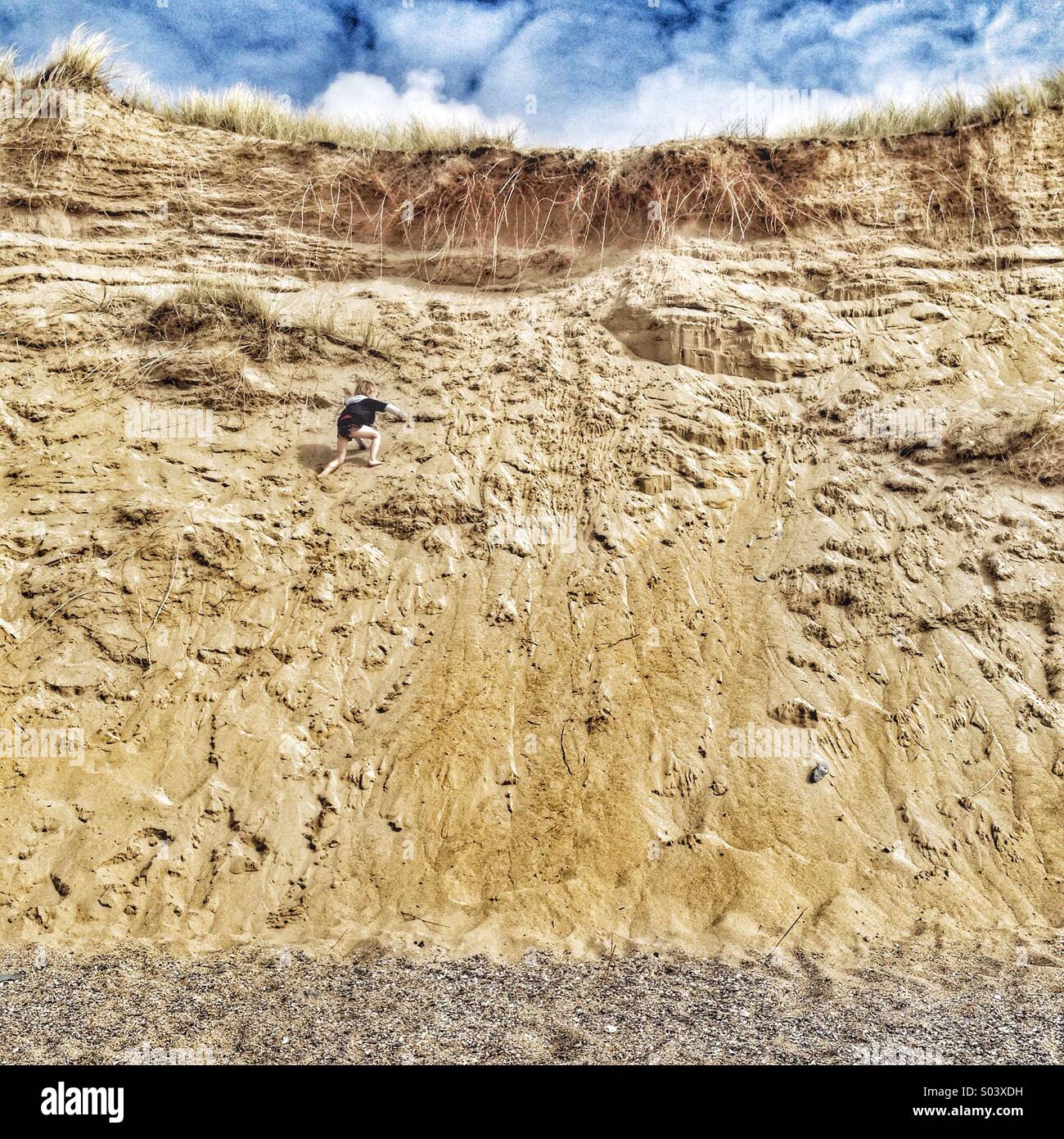 Boy climbing the dunes at Holywell Bay in Cornwall - Smartphone Captured Stock Image