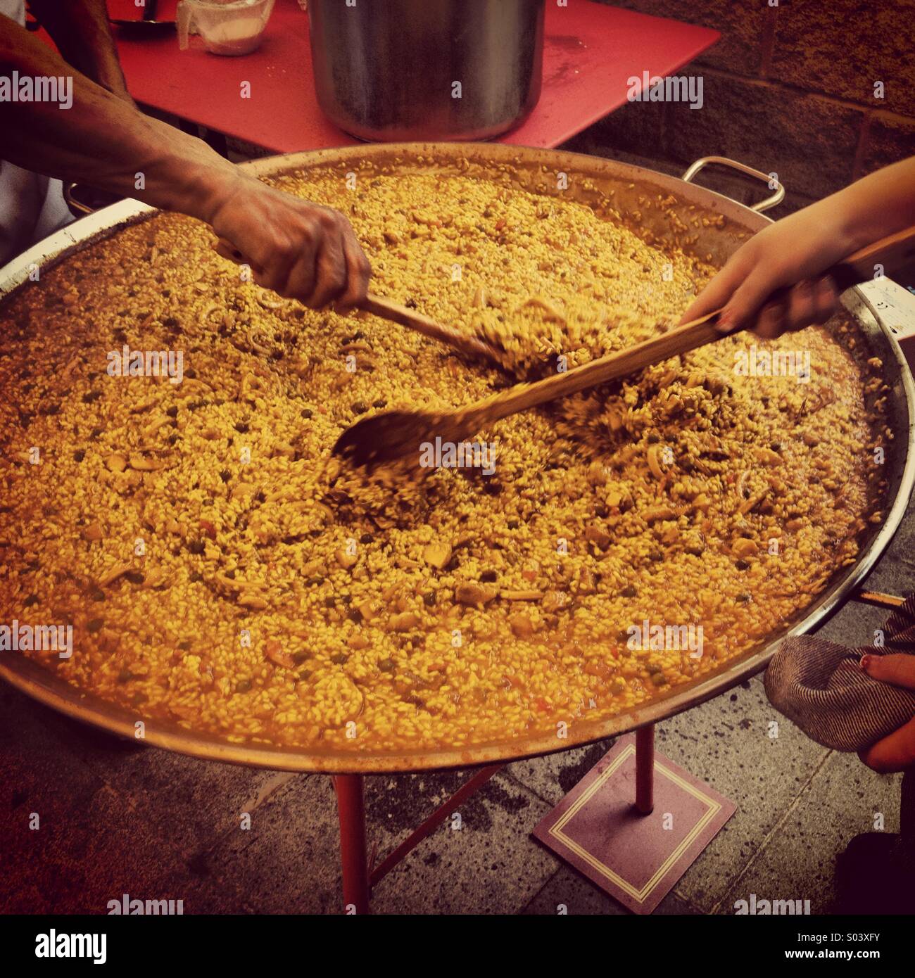 Hands stirring huge dish of paella Stock Photo