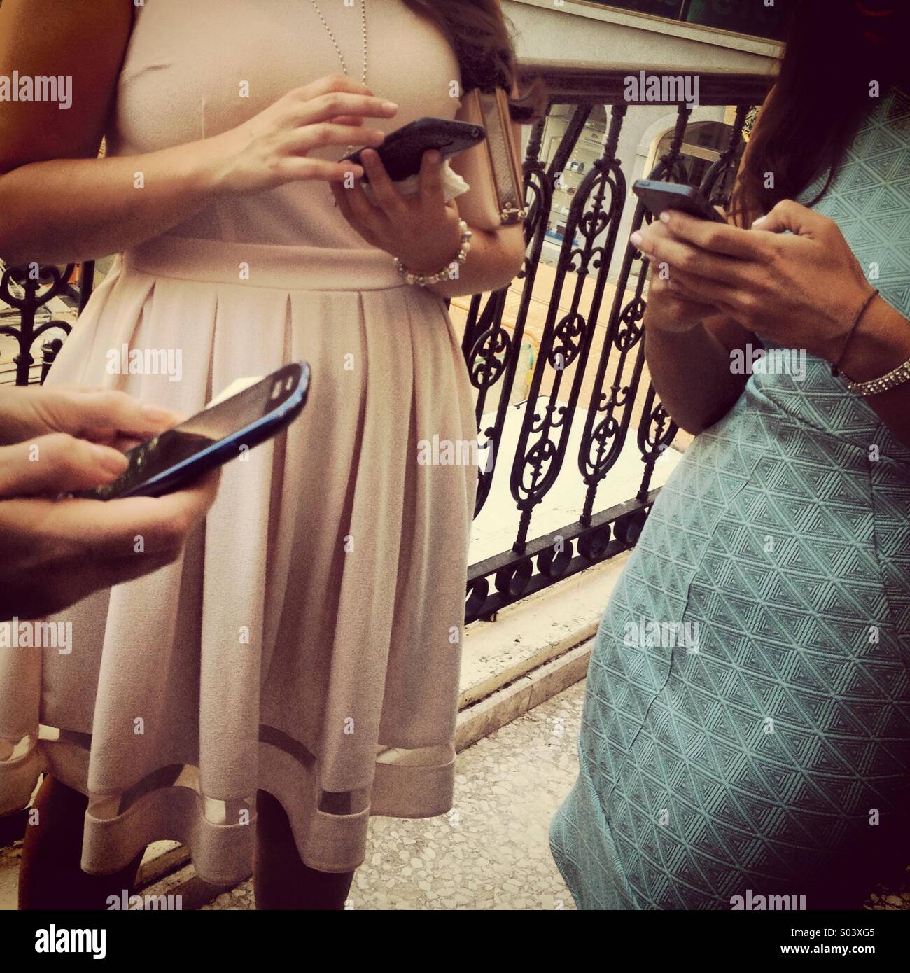 People standing using mobile phones for texting and social media Stock Photo