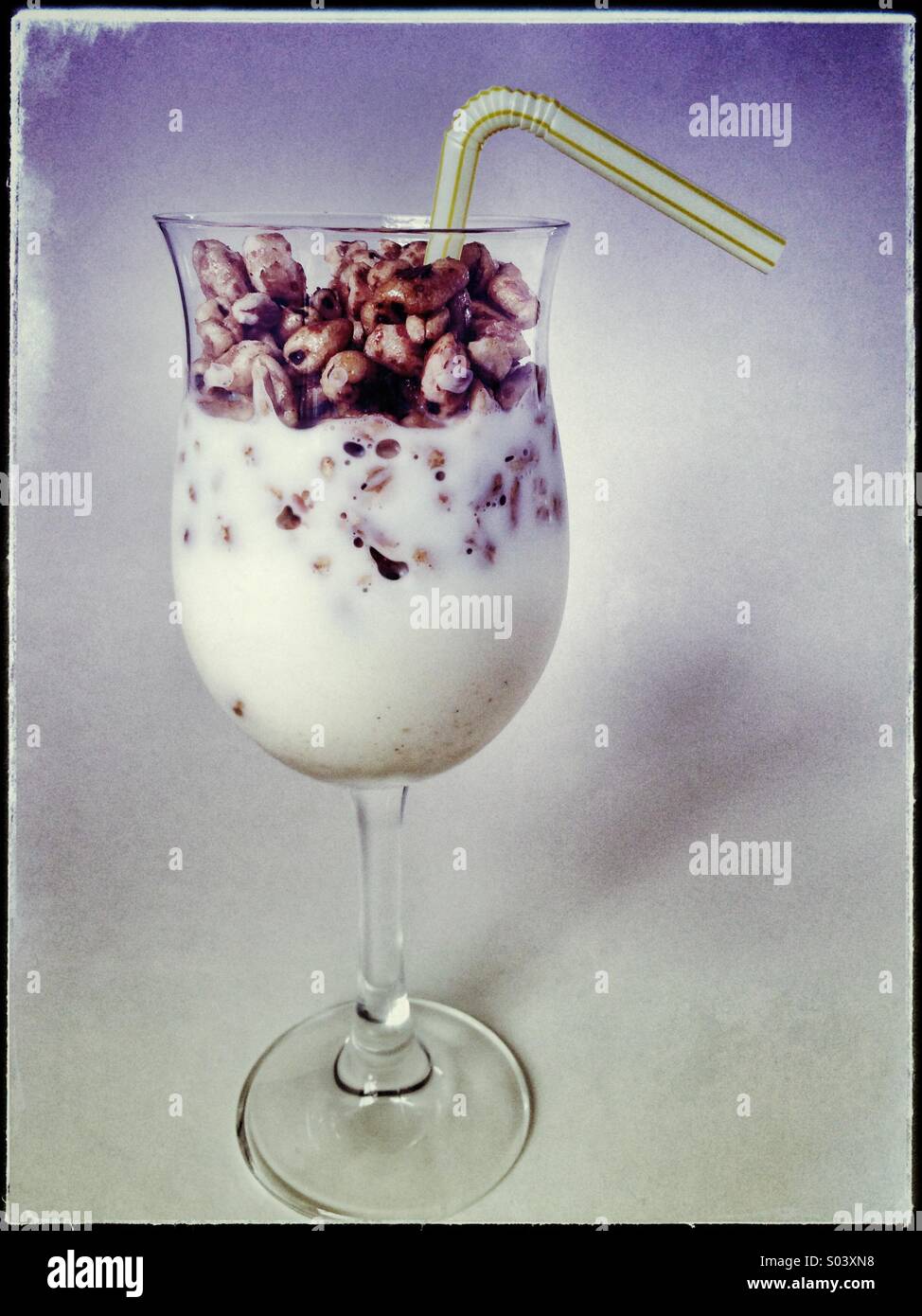 Puffed wheat cereal and milk in a drinking glass topped off with a