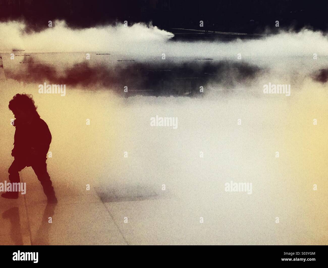 Child playing in a fountain of fluffy mist - Smartphone Captured Stock Image