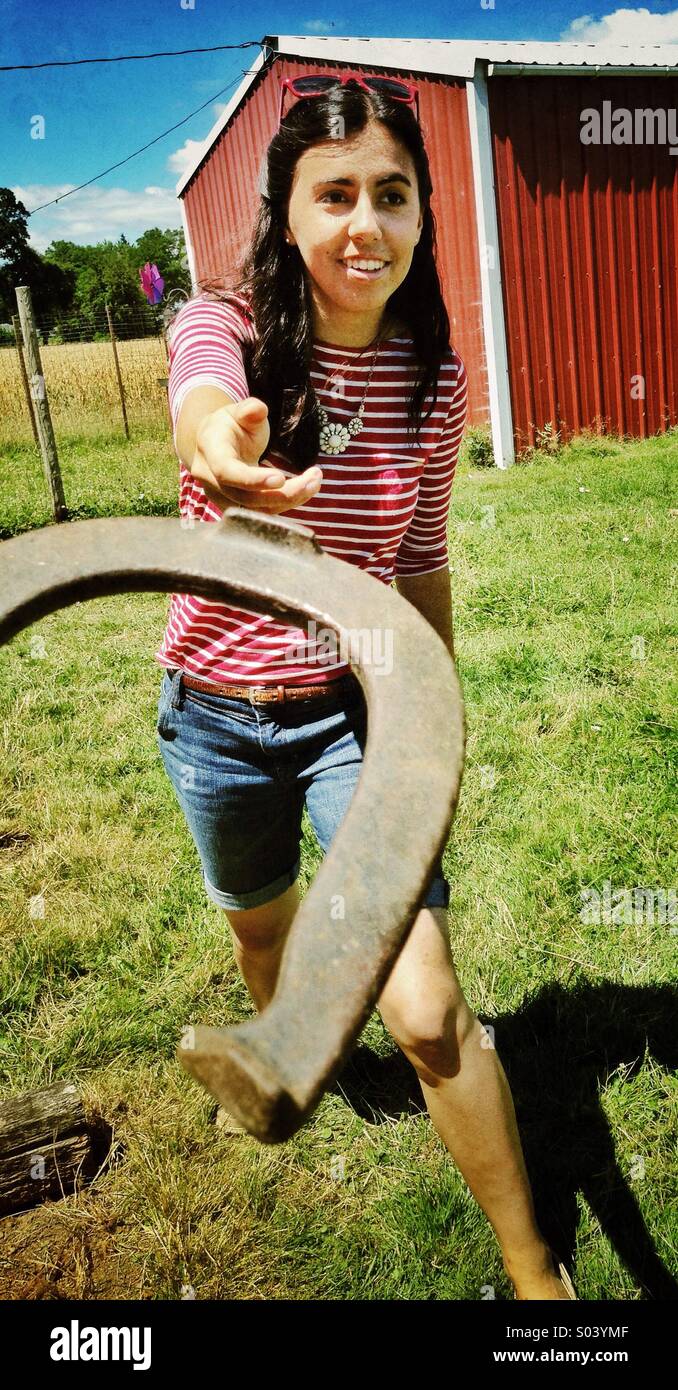 Teenage girl throwing horseshoe Stock Photo Alamy