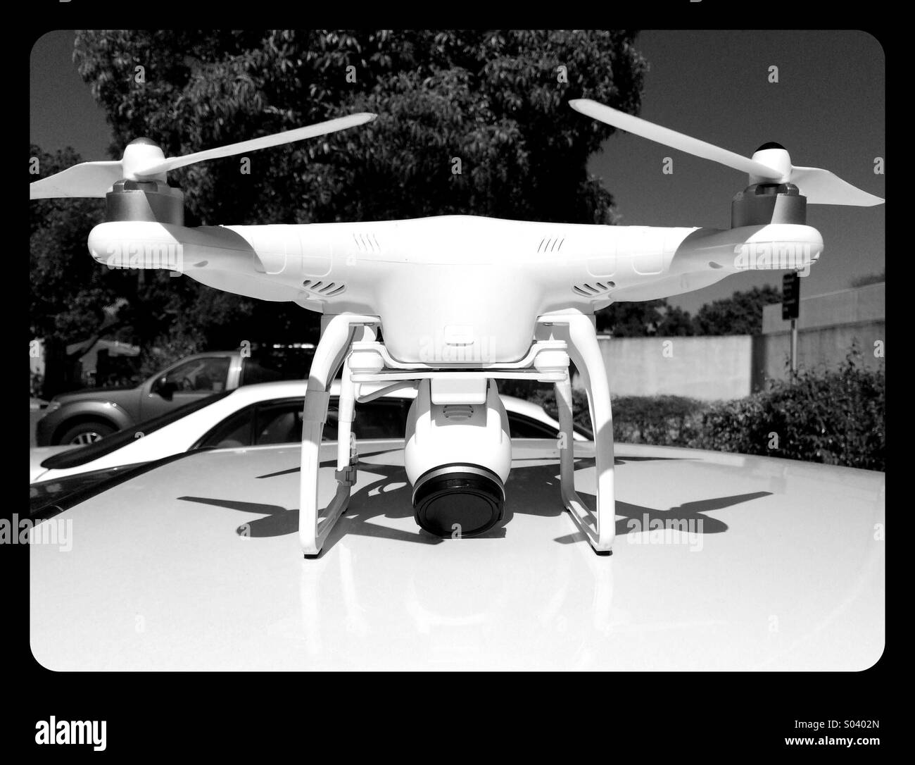 White Drone on a White Car - Smartphone Captured Stock Image