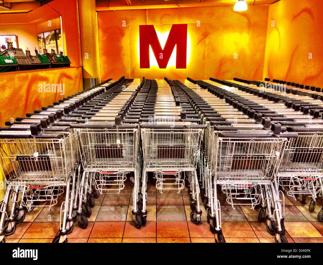 Supermarket trolleys lined up in a Migros store Stock Photo
