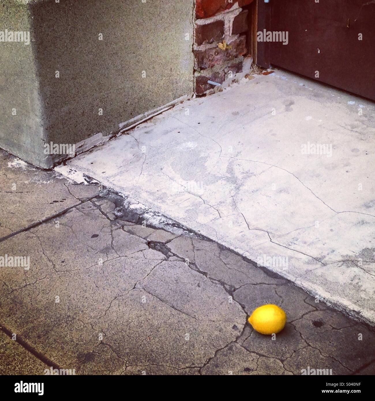 Sidewalk Still Life with Fallen Lemon Stock Photo
