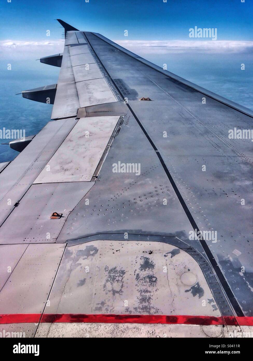 View of airplane wing through window of airplane - Smartphone Captured Stock Image