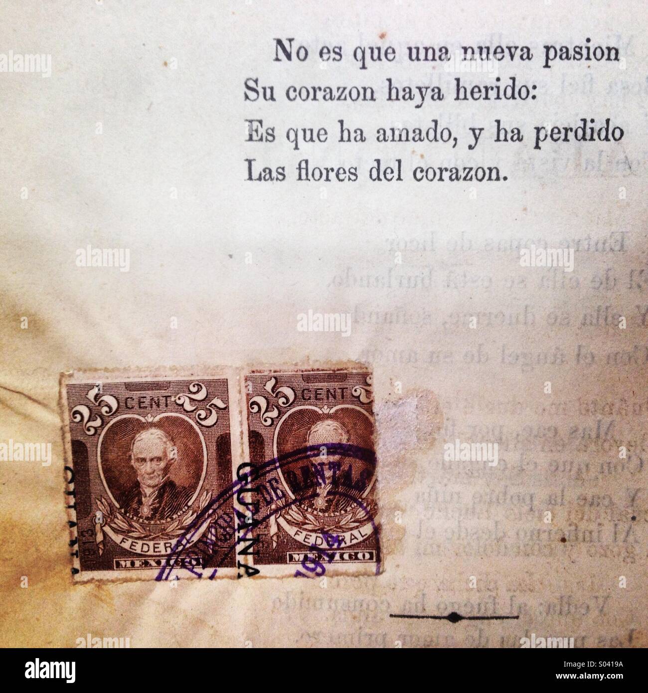 Two postage stamps decorate an old poetry book in 'Librero en Andanzas' used books store in Colonia Roma, Mexico City, Mexico - Smartphone Captured Stock Image