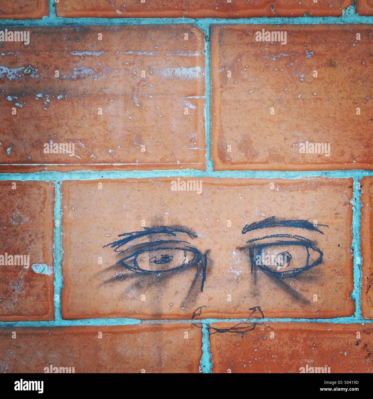 Two eyes painted with pencil in a red wall in Colonia Roma, Mexico City, Mexico - Smartphone Captured Stock Image