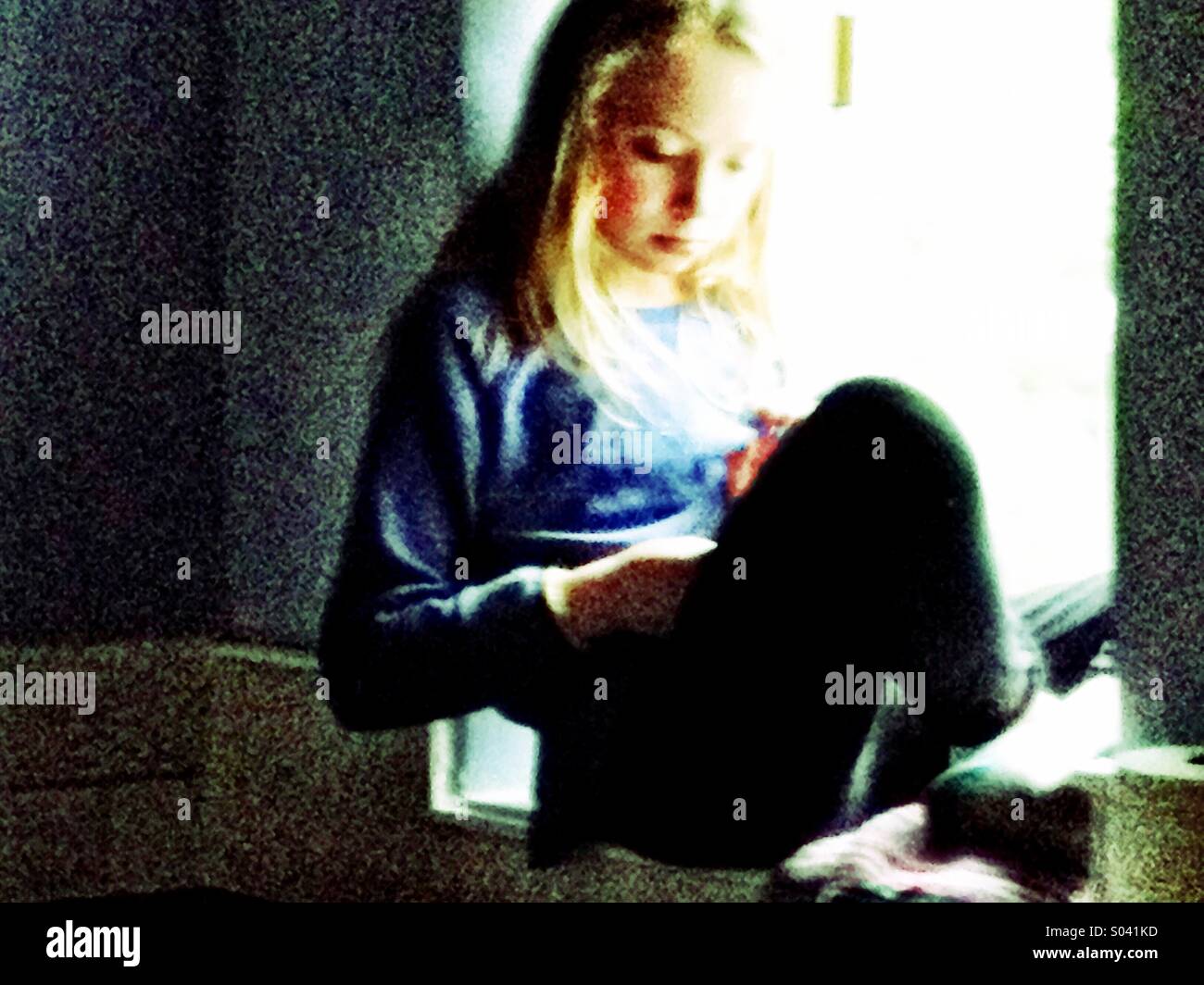 Girl reading at window - Smartphone Captured Stock Image