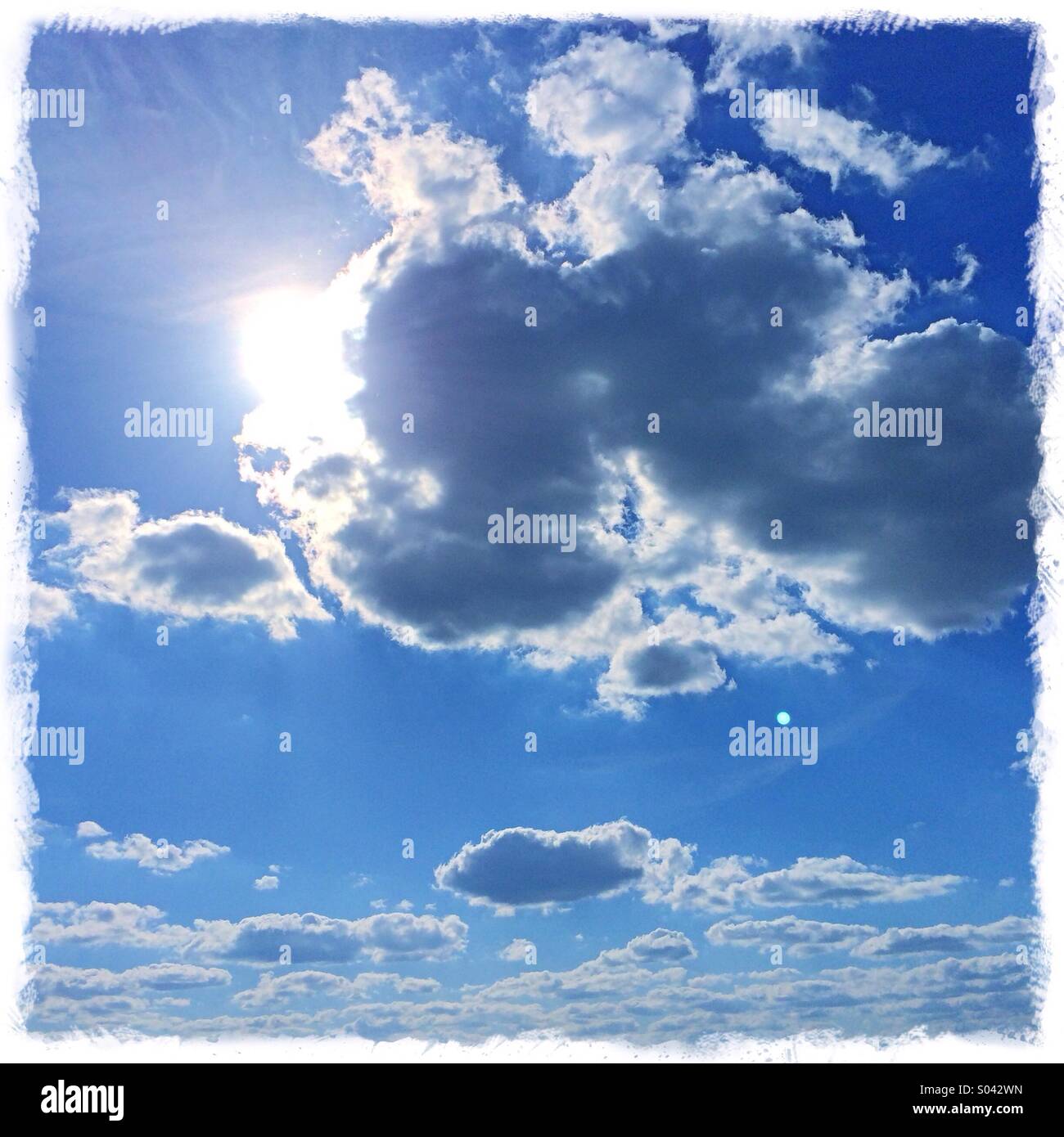 Blue sky sunshine and clouds UK Stock Photo