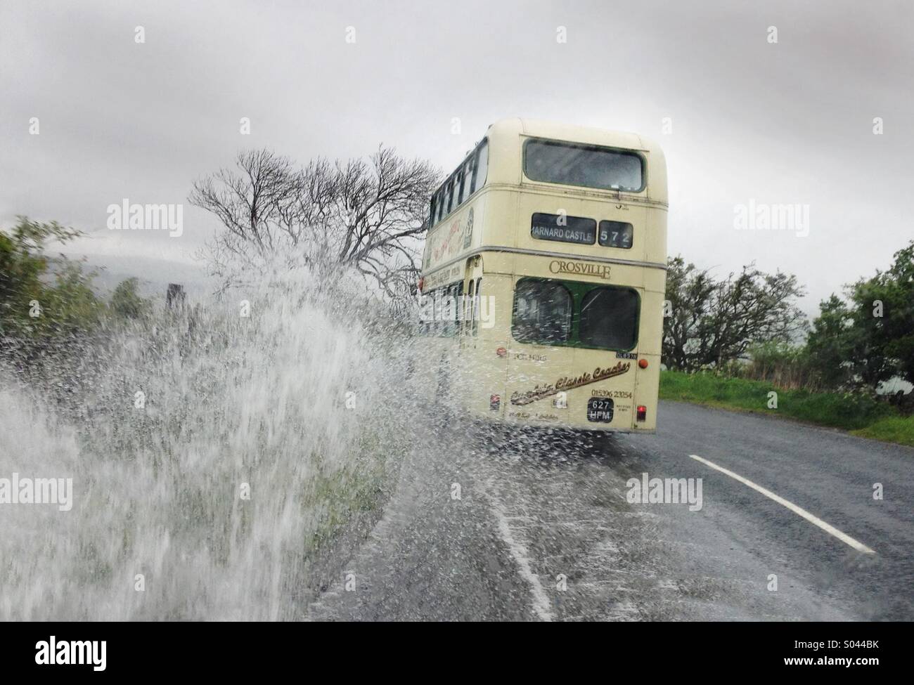 Heavy rains create difficult driving conditions for this Classic 1959 Leyland Lodekka Bus as it travels on the Brough to Middleton-in-Teesdale Road in the Pennines Hills, Co Durham, England Stock Photo