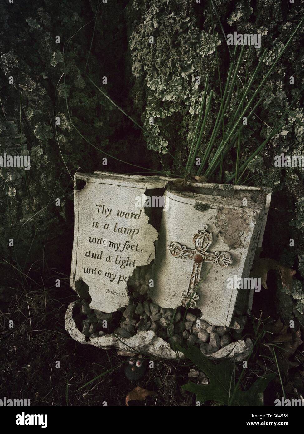 An abandoned bible in a cemetery that says 'thy word is a lamp into my par hand a light into my feet'. From Psalms - Smartphone Captured Stock Image