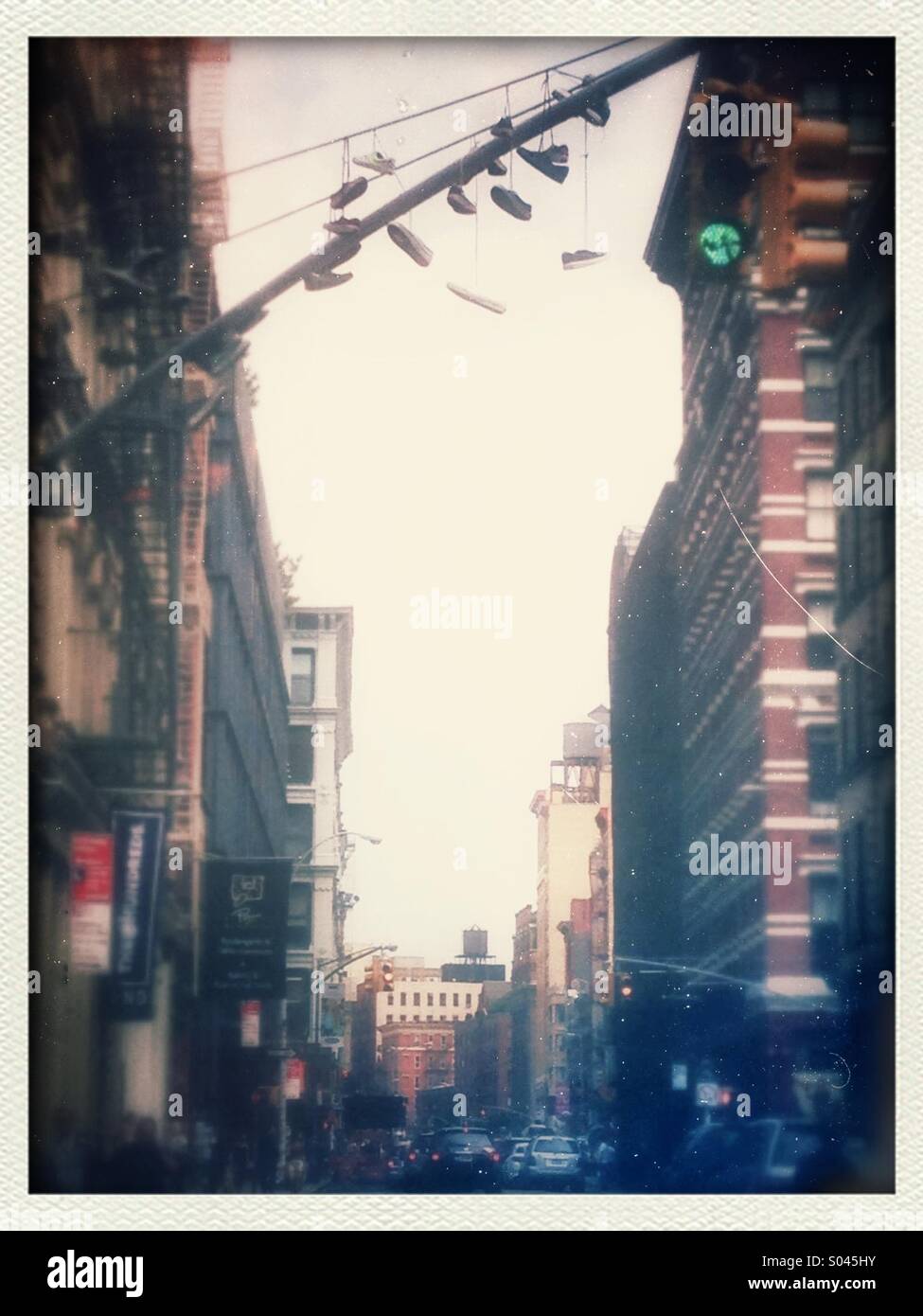 Several discarded sneakers and shoes hanging from lamppost in New York City St. - Smartphone Captured Stock Image