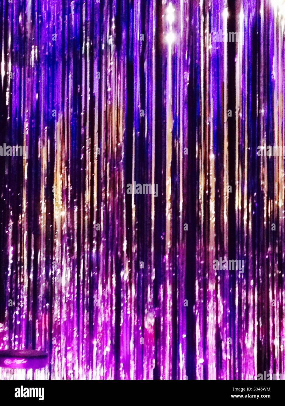 Brightly coloured violet purple silver sparkly stage backdrop Stock Photo